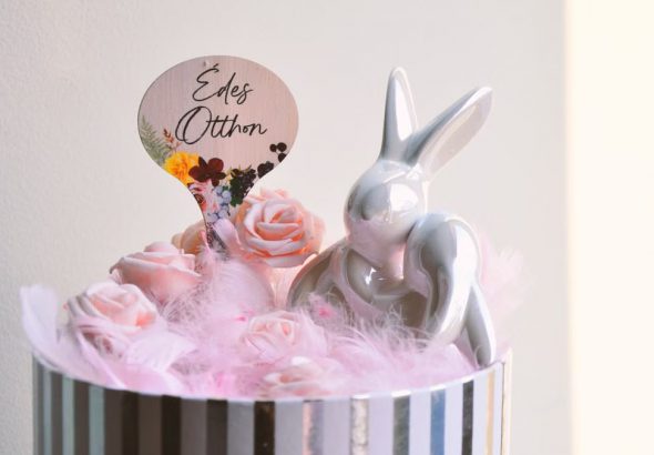 Charming Easter decoration with a ceramic bunny and pink roses in a striped box.