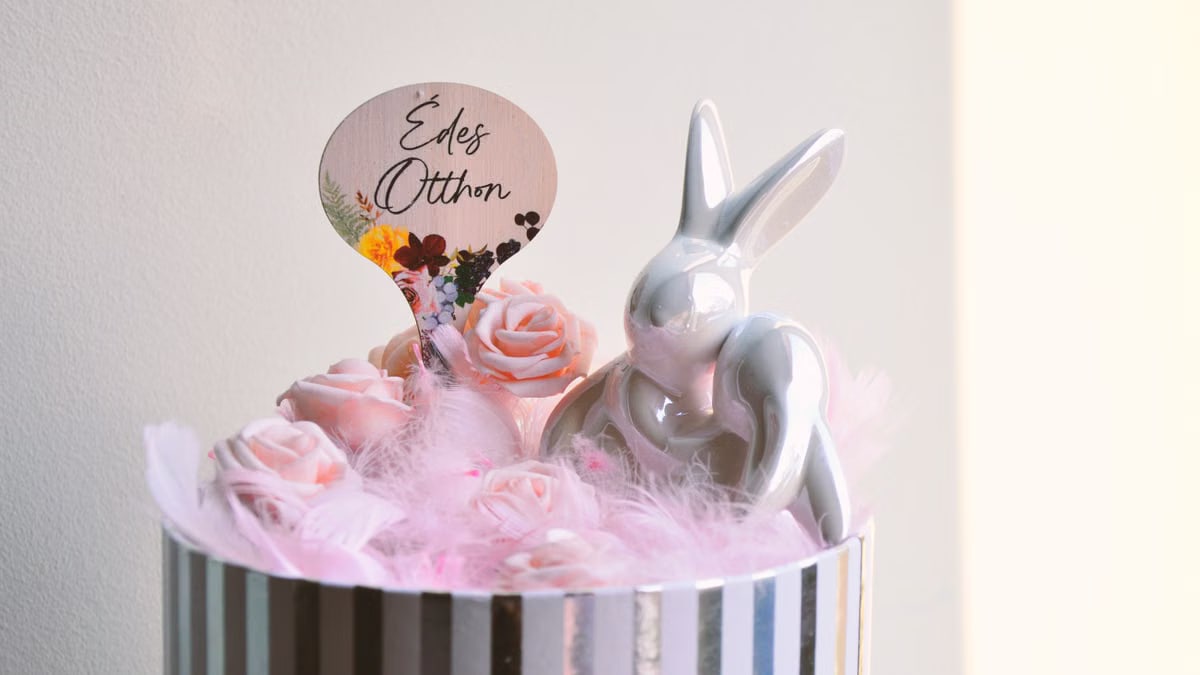 Charming Easter decoration with a ceramic bunny and pink roses in a striped box.