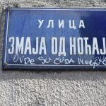 a blue street sign on the side of a building