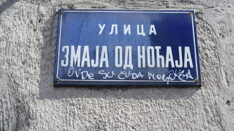 a blue street sign on the side of a building